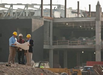 Three men contractors discussing a building plan