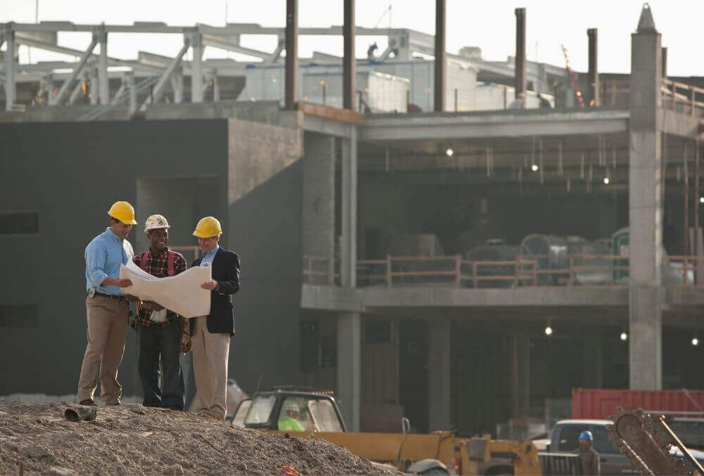 Three men contractors discussing a building plan