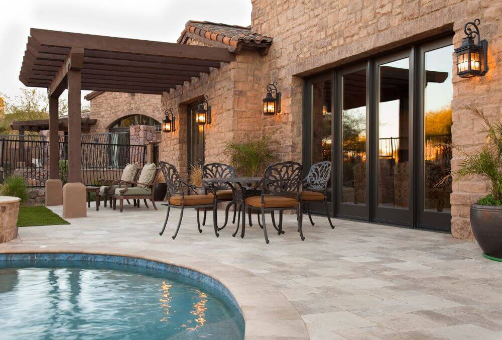 brick walled house with pergola and a stamped concrete pool deck