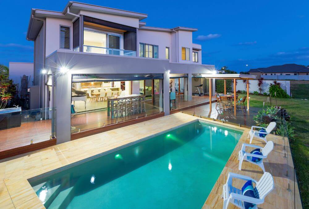 2-storey house well lit with an outdoor pool