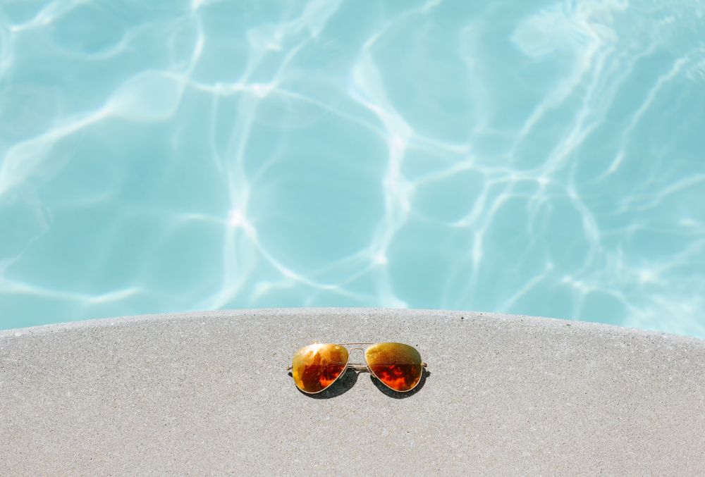 sunglasses on a concrete pool deck